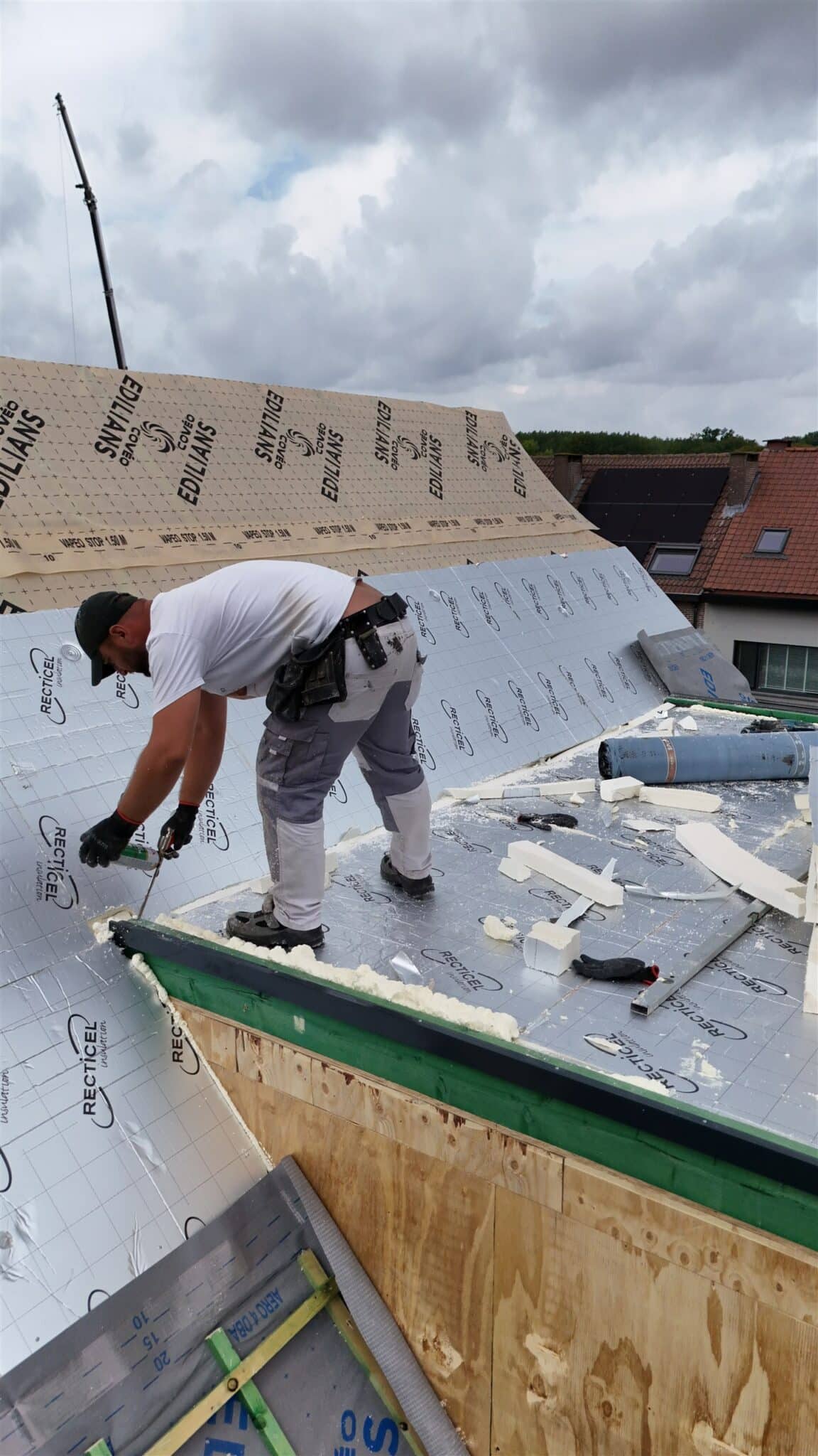 Werkmannen isoleren een hellend dak met PIR-platen bij Cralux