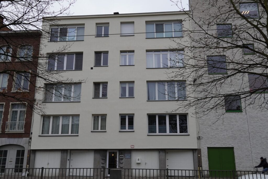 Straatgevel van een appartementsgebouw in Antwerpen na gevelrenovatie met lichte crepi