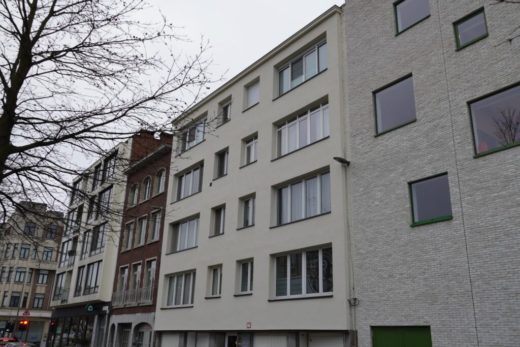 Zijaanzicht van een appartementsgebouw in Antwerpen na gevelrenovatie met lichte crepi