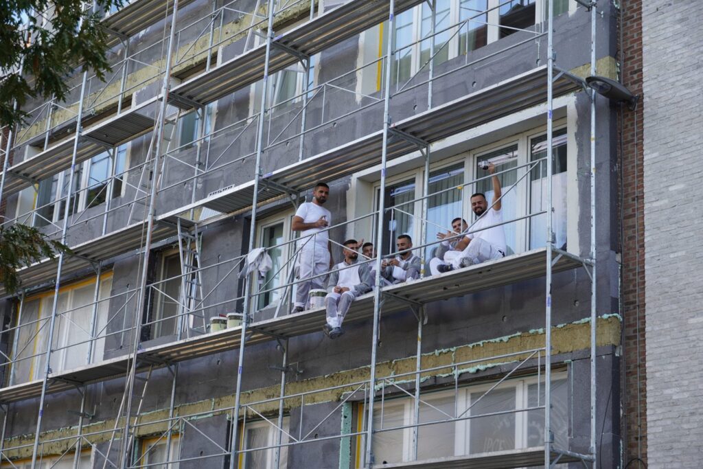 Appartementsgebouw in Antwerpen in de steigers tijdens de gevelrenovatie, met Cralux-werfdoeken