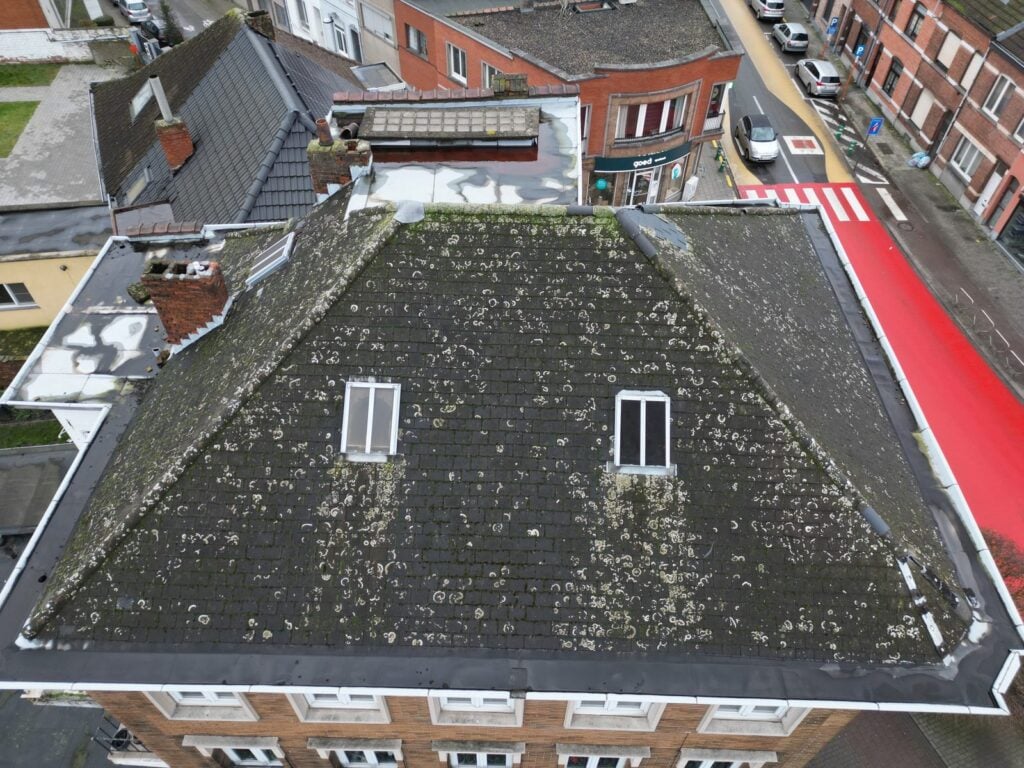 Dronebeeld van het verweerde dak van een appartementsgebouw in Vilvoorde v&oacute;&oacute;r de dakrenovatie
